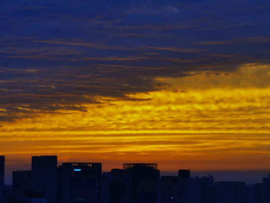 Golden-hour clouds over a city silhouette