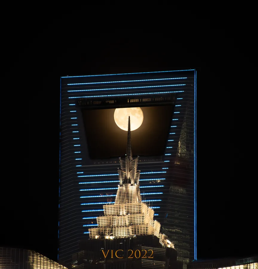 Full moon framed in the aperture of the Shanghai World Financial Center, Jin Mao spire below